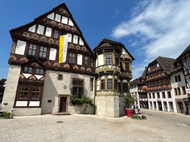 Historische Gebäude mit Fachwerk und verzierten Fassaden in einer malerischen Stadt.